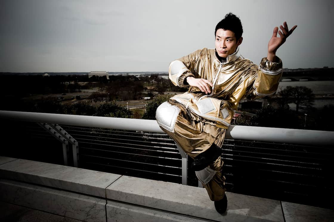 金色の衣装で手すりに座るEBIKEN・蛯名健一