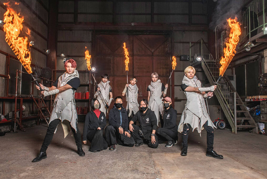 松明を持った5人と他4人の集合写真