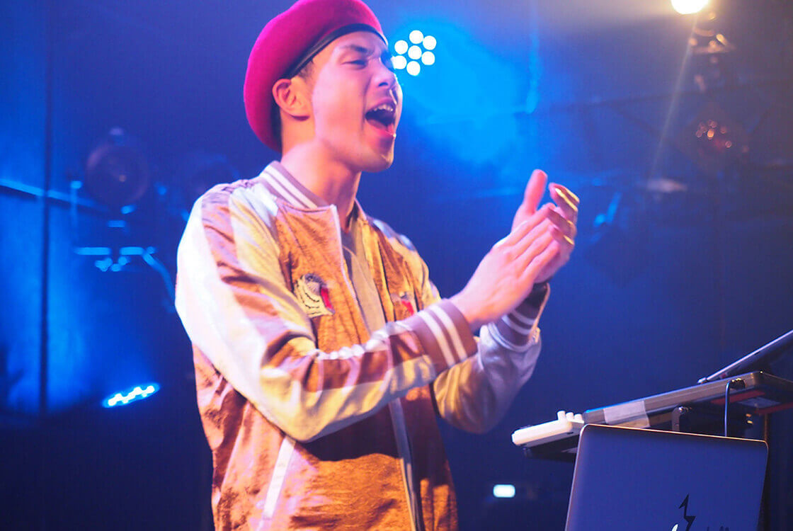 ライブでベレー帽をかぶって手をたたき歌うREATMO