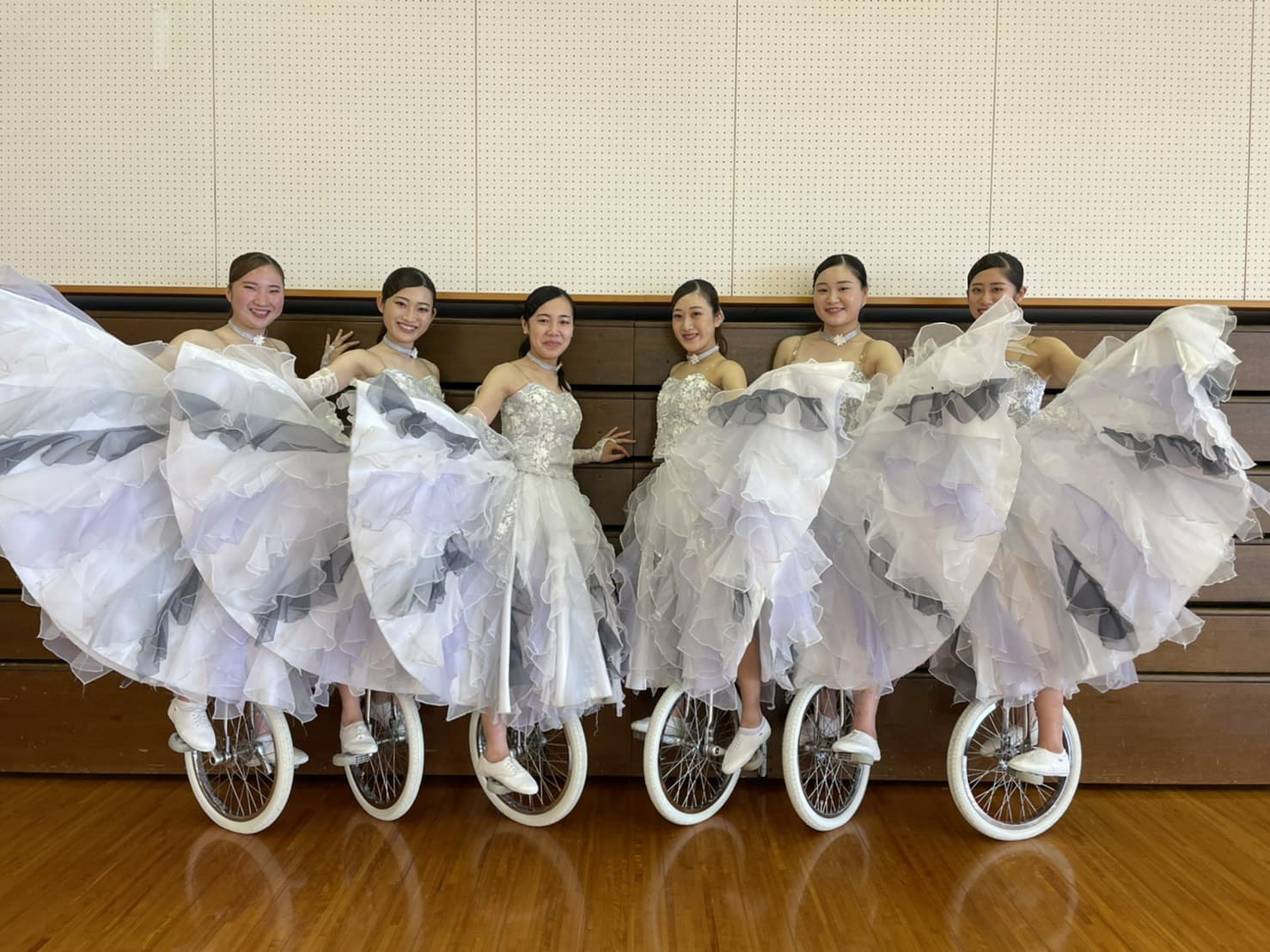 白い衣装で一輪車に乗った6人の集合写真